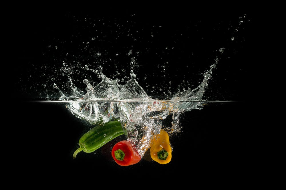 Peppers splashing into water